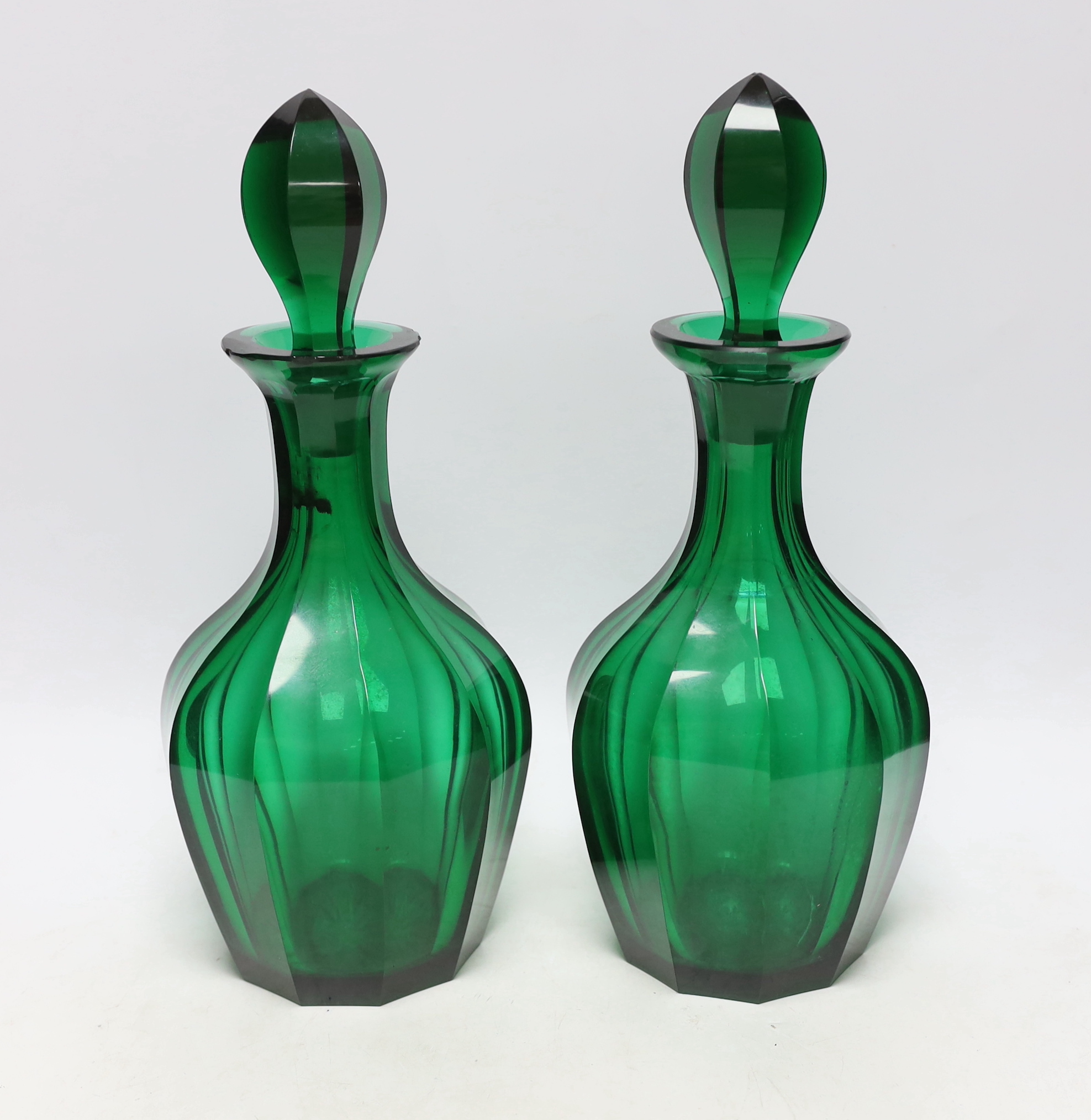 A pair of 19th century green glass decanters with stoppers, 34cm high